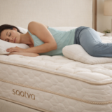 Woman in blue shirt sleeping on saatva mattress