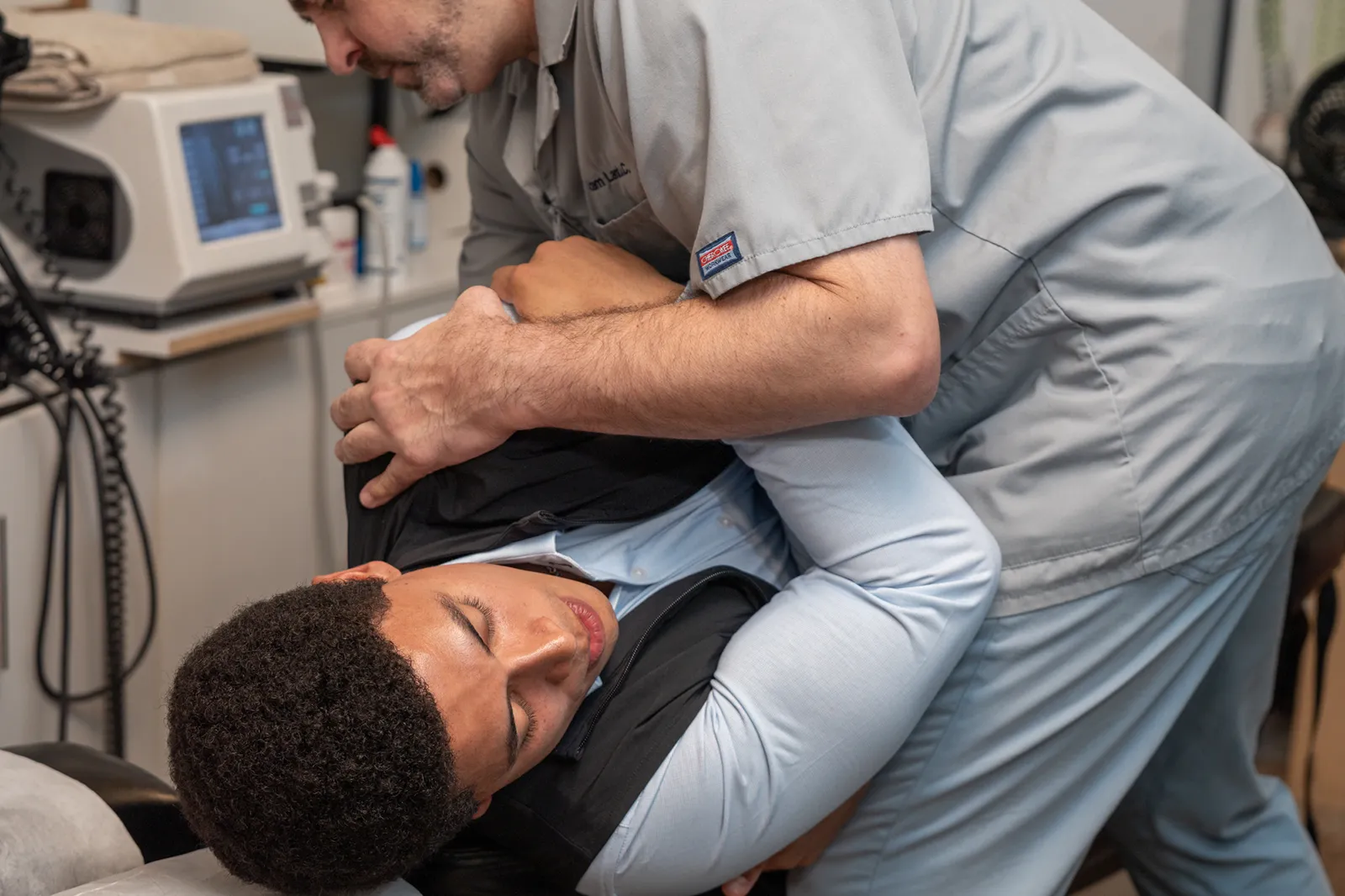 Dr. Adam Lamb performing a sacral adjustment for a sciatica patient at his NYC chiropractic office