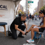 Chiropractor applying kinesiotape to a female athletes leg
